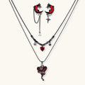 Gothic jewelry set with asymmetrical black metal earrings featuring red crescent moons, stars, and layered necklaces with heart pendants